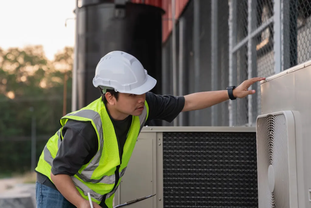 HVAC technician inspecting air handlers unit in Cheverly, Maryland. Maintenance of industrial air conditioning systems. Expert repair service.